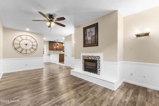 3139 Clifford Dr, Lima, OH 45805 - unfurnished living room featuring wainscoting, ceiling fan, dark wood-style flooring, and a glass covered fireplace