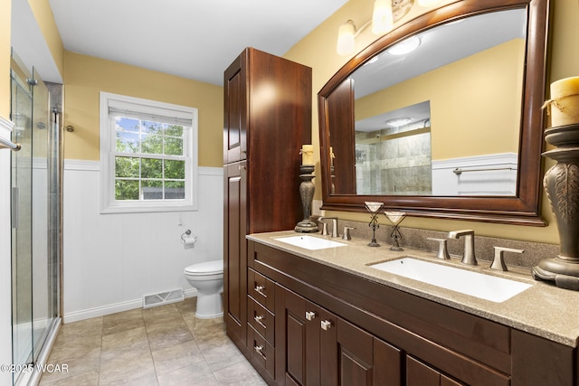 3139 Clifford Dr, Lima, OH 45805 - full bath with double vanity, tiled shower, and wainscoting