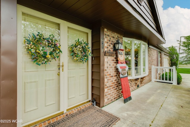 5295 E Rd, Lima, OH 45807 - doorway to property featuring a porch and brick siding
