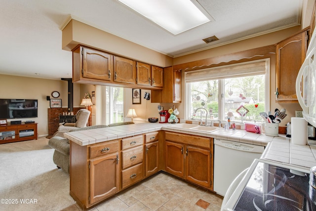 5295 E Rd, Lima, OH 45807 - kitchen with brown cabinets, white dishwasher, a sink, a peninsula, and open floor plan