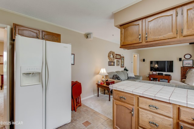 5295 E Rd, Lima, OH 45807 - kitchen featuring ornamental molding, baseboards, open floor plan, tile countertops, and white fridge with ice dispenser
