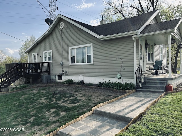view of home's exterior featuring a chimney, a yard, stairway, roof with shingles, and cooling unit