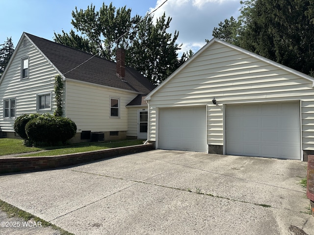 400 N Westminster St, Waynesfield, OH 45896 - view of side of property with driveway, an outbuilding, a chimney, and an attached garage