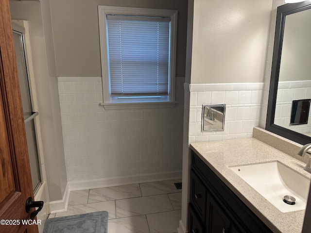 400 N Westminster St, Waynesfield, OH 45896 - bathroom with marble finish flooring, vanity, a wainscoted wall, and tile walls