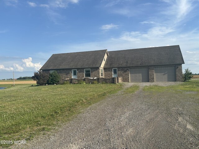 25853 Rd M, Cloverdale, OH 45827 - view of front of home with brick siding, dirt driveway, an attached garage, and roof with shingles