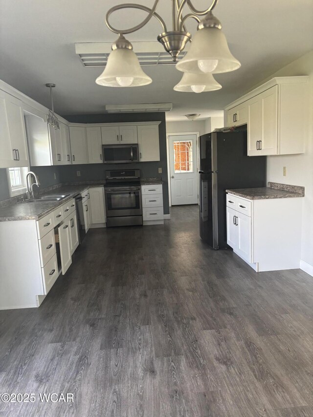 25853 Rd M, Cloverdale, OH 45827 - kitchen featuring appliances with stainless steel finishes, white cabinetry, dark wood-style flooring, pendant lighting, and dark countertops