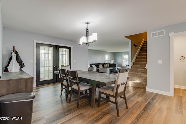 dining room with a notable chandelier, hardwood / wood-style flooring, and french doors