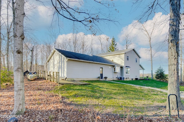 back of house with cooling unit and a lawn