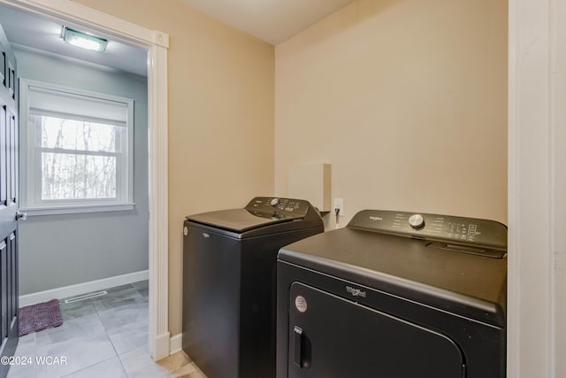 laundry room with separate washer and dryer and light tile patterned floors