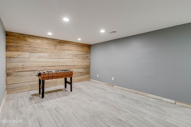 interior space with wooden walls and light hardwood / wood-style floors