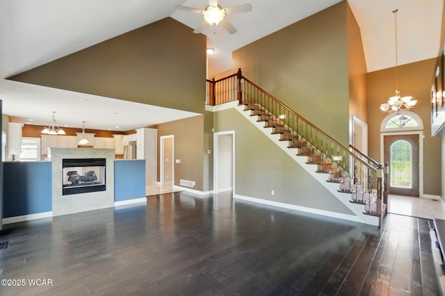 4441 Indian Hill Dr, Lima, OH 45806 - unfurnished living room featuring high vaulted ceiling, stairway, baseboards, ceiling fan, and a chandelier