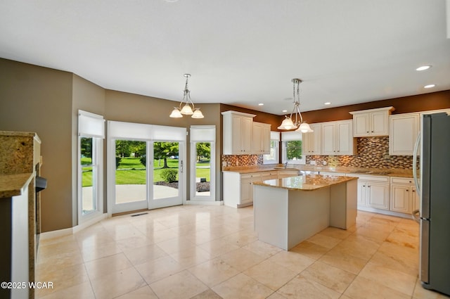 4441 Indian Hill Dr, Lima, OH 45806 - kitchen with freestanding refrigerator, backsplash, a kitchen island, black electric cooktop, and recessed lighting