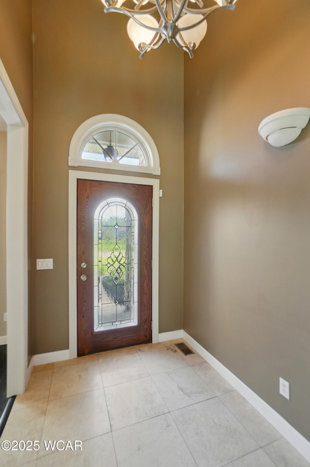 4441 Indian Hill Dr, Lima, OH 45806 - tiled entryway with a chandelier, a high ceiling, and baseboards