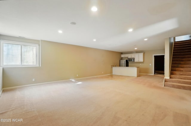 4441 Indian Hill Dr, Lima, OH 45806 - unfurnished living room with light colored carpet, stairway, baseboards, and recessed lighting