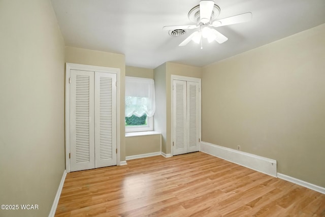 2619 Wendell Ave, Lima, OH 45805 - unfurnished bedroom featuring multiple closets, light wood-style flooring, and ceiling fan