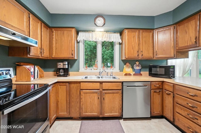 2619 Wendell Ave, Lima, OH 45805 - kitchen featuring appliances with stainless steel finishes, light countertops, wall chimney range hood, brown cabinets, and light tile patterned floors