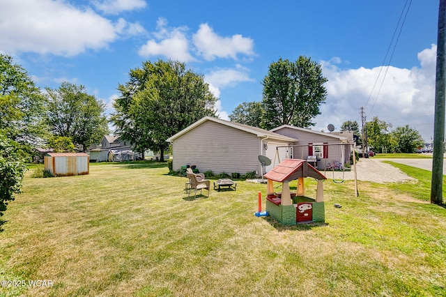 view of yard with a storage shed and an outdoor fire pit