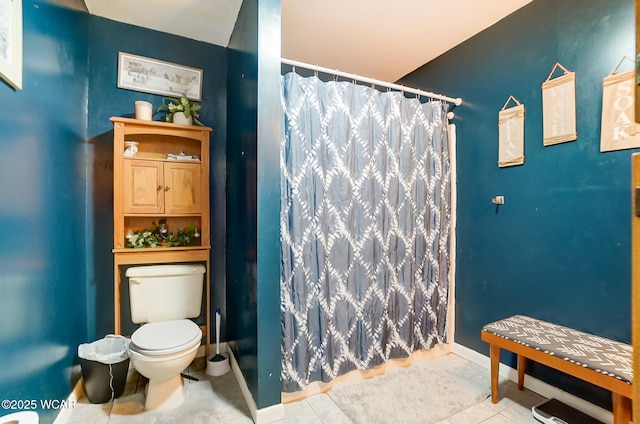 bathroom with curtained shower, tile patterned floors, and toilet