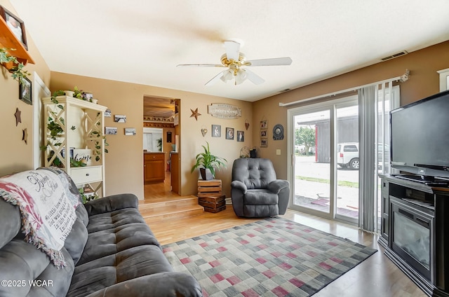 living room featuring ceiling fan and light hardwood / wood-style flooring