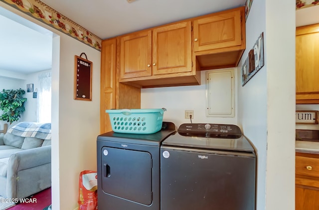 laundry area with cabinets, independent washer and dryer, and electric panel