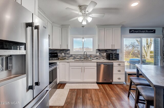 1280 Wonderlick Rd, Lima, OH 45805 - kitchen featuring stainless steel appliances, a sink, ceiling fan, backsplash, and light wood-style floors