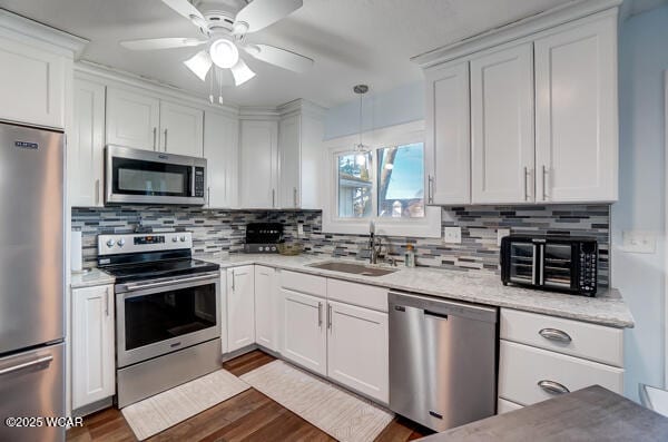 1280 Wonderlick Rd, Lima, OH 45805 - kitchen featuring stainless steel appliances, a sink, white cabinetry, ceiling fan, and tasteful backsplash