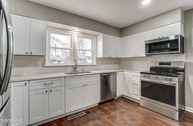 kitchen featuring stainless steel appliances, sink, and white cabinets