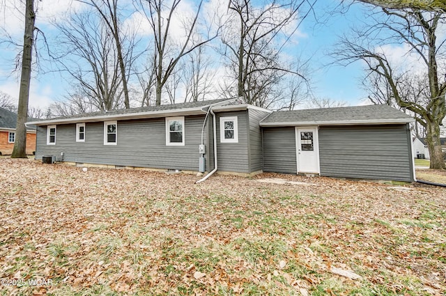 rear view of property featuring a garage and central air condition unit