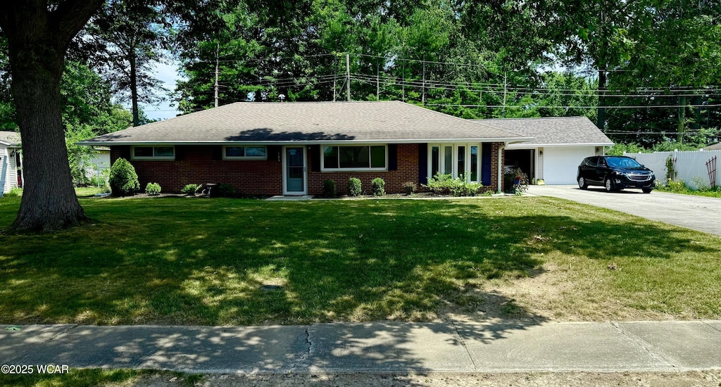 715 Wildwood Ave, Lima, OH 45807 - ranch-style home with concrete driveway, brick siding, and an attached garage
