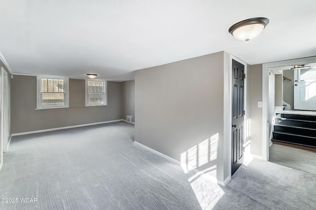 carpeted spare room with visible vents and baseboards