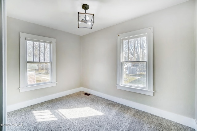 empty room featuring visible vents, baseboards, and carpet flooring