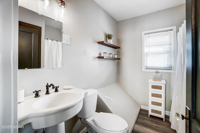 bathroom featuring baseboards, toilet, and wood finished floors