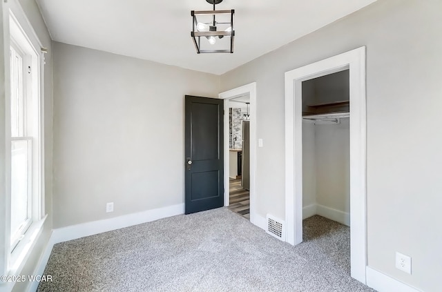 unfurnished bedroom featuring visible vents, baseboards, carpet, and a closet