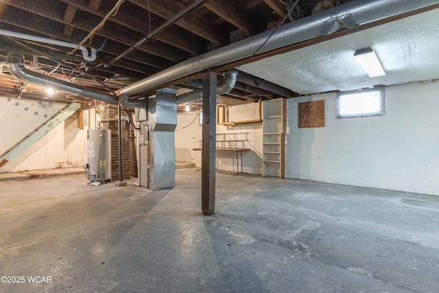 basement featuring gas water heater, concrete block wall, and heating unit