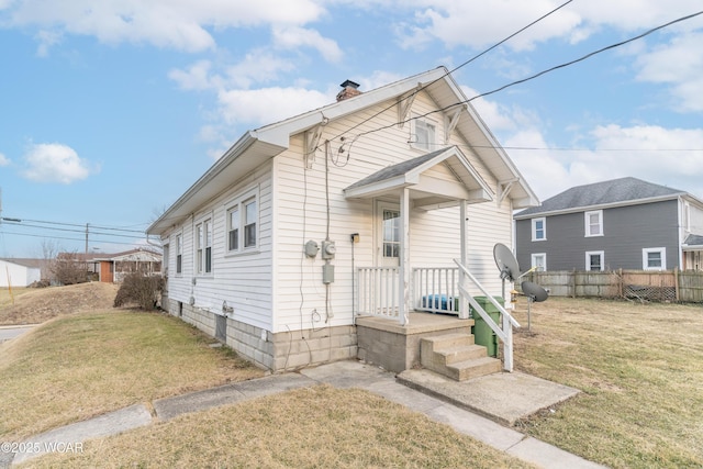 view of front of home featuring a front lawn, fence, and a chimney