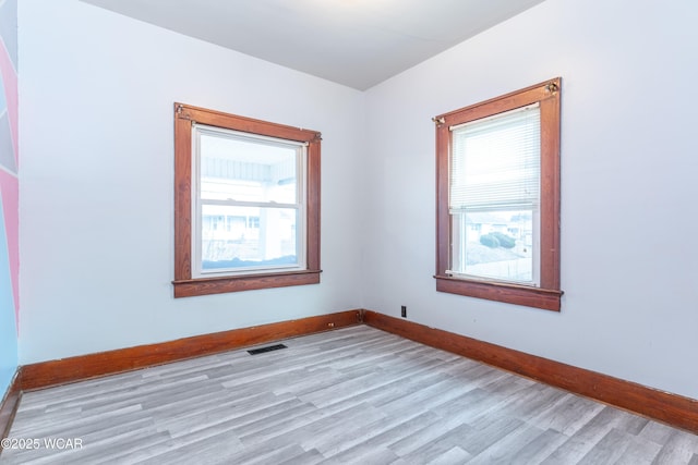 spare room featuring visible vents, baseboards, and light wood-style flooring