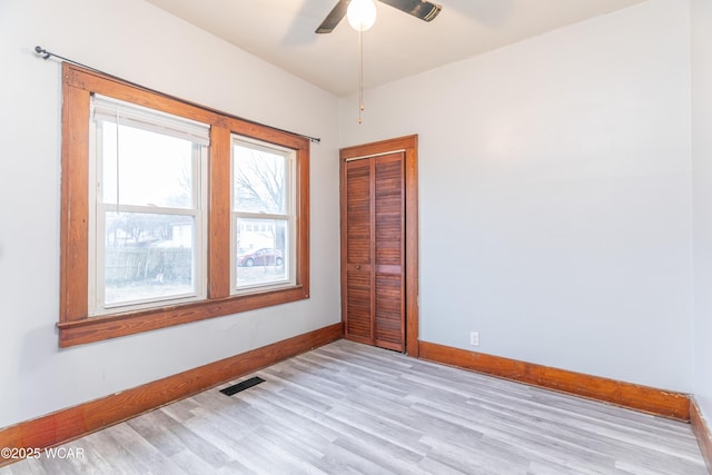 unfurnished room featuring visible vents, a ceiling fan, light wood-type flooring, and baseboards