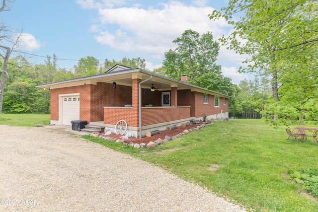 1380 Thomas Rd, New Paris, OH 45347 - view of home's exterior with driveway, a ceiling fan, brick siding, a yard, and an attached garage