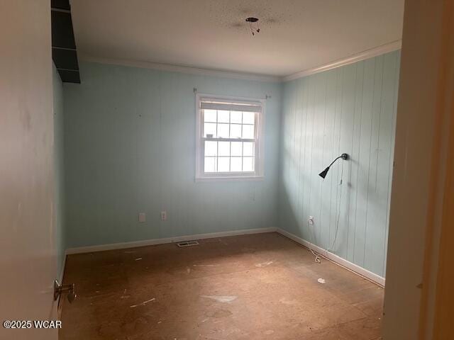 empty room featuring crown molding