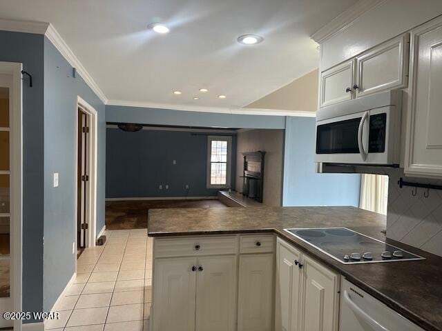 kitchen with stainless steel appliances, ornamental molding, white cabinets, and kitchen peninsula