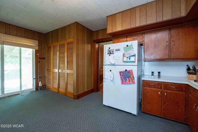 15350 State Route 235, Mount Cory, OH 45868 - kitchen with freestanding refrigerator, dark carpet, light countertops, brown cabinets, and wooden walls
