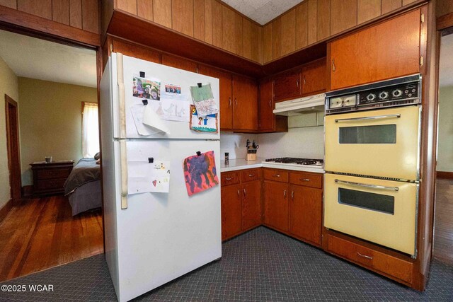 15350 State Route 235, Mount Cory, OH 45868 - kitchen featuring freestanding refrigerator, multiple ovens, under cabinet range hood, brown cabinets, and light countertops