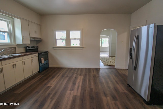 458 W Mckibben St, Lima, OH 45801 - kitchen featuring appliances with stainless steel finishes, under cabinet range hood, a sink, arched walkways, and white cabinetry