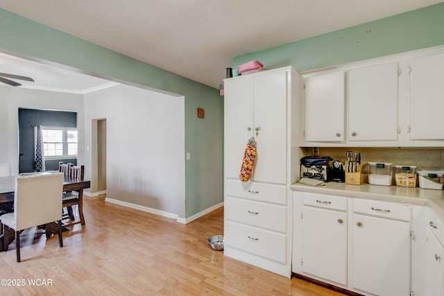 213 Johns Ave, Elida, OH 45807 - kitchen featuring light countertops, white cabinets, light wood-type flooring, baseboards, and ceiling fan