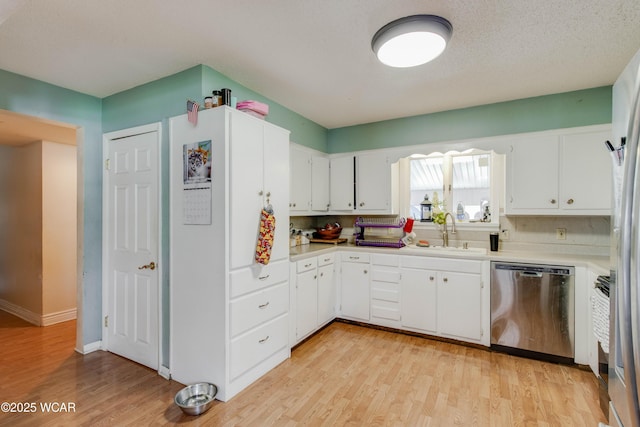 213 Johns Ave, Elida, OH 45807 - kitchen featuring stainless steel dishwasher, a sink, light wood-style floors, light countertops, and white cabinetry