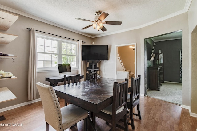 213 Johns Ave, Elida, OH 45807 - dining area featuring wood finished floors, stairway, ceiling fan, crown molding, and baseboards