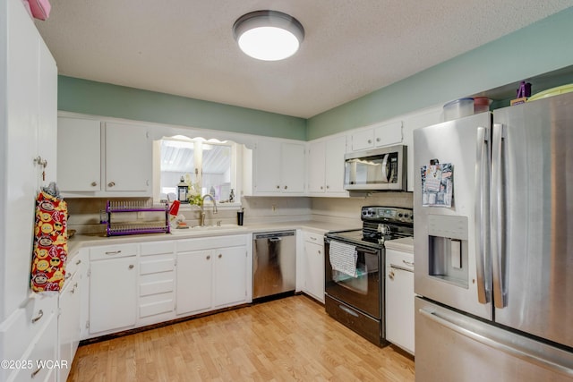 213 Johns Ave, Elida, OH 45807 - kitchen featuring stainless steel appliances, a sink, light countertops, light wood-style flooring, and white cabinets