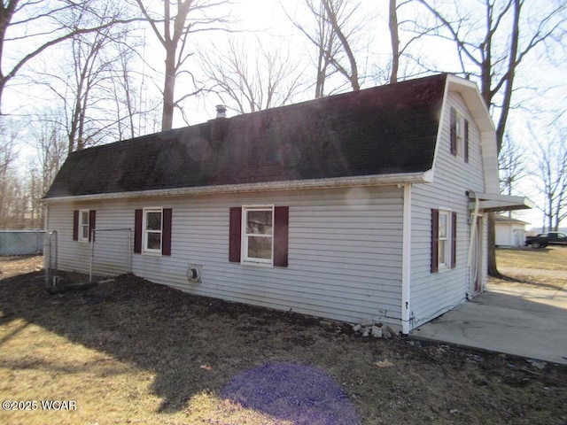 view of front of house featuring a chimney, a gambrel roof, and a shingled roof