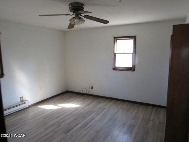 unfurnished room featuring baseboards, baseboard heating, wood finished floors, and a ceiling fan