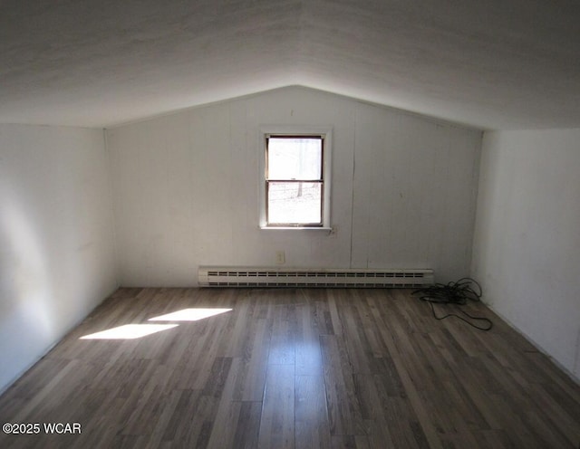 additional living space with baseboard heating, wood finished floors, and vaulted ceiling